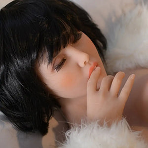 4ft 11in 150cm Asian sex doll with medium length black hair, light skin, b-cup breasts with closed eyes in yellow underwear.  Made by 6ye.