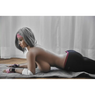 5ft 2in 158cm curvy Asian TPE sex doll with silver hair, large I cup breasts brown eyes and tanned skin in sports bra and tight pants.