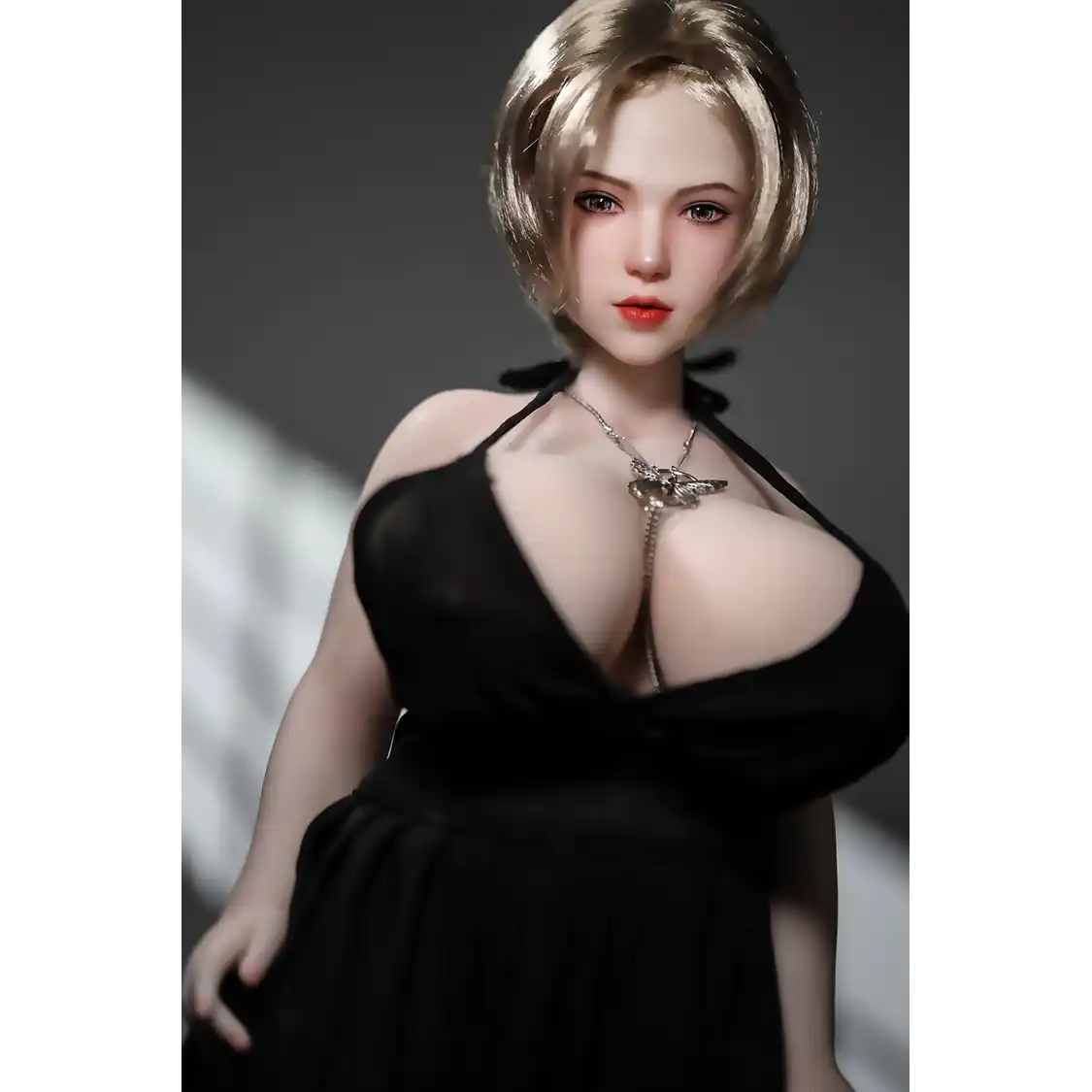 1ft 11in 60cm white female mini silicone sex doll with blonde hair, light skin and extra large breasts.