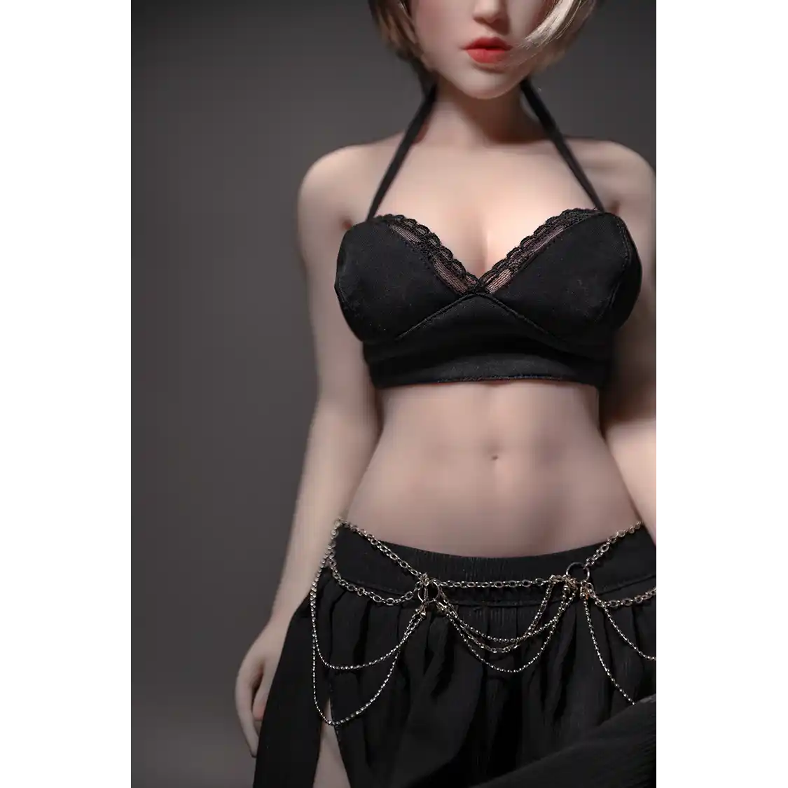 1ft 11in 60cm white female mini silicone sex doll with blonde hair, light skin and large breasts.