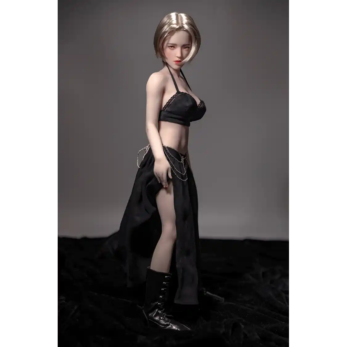 1ft 11in 60cm white female mini silicone sex doll with blonde hair, light skin and large breasts.