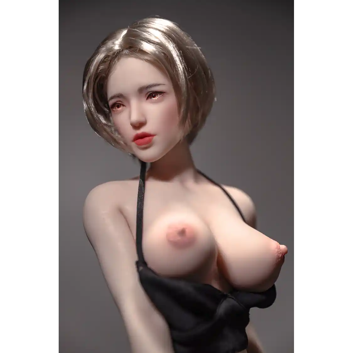 1ft 11in 60cm white female mini silicone sex doll with blonde hair, light skin and large breasts.