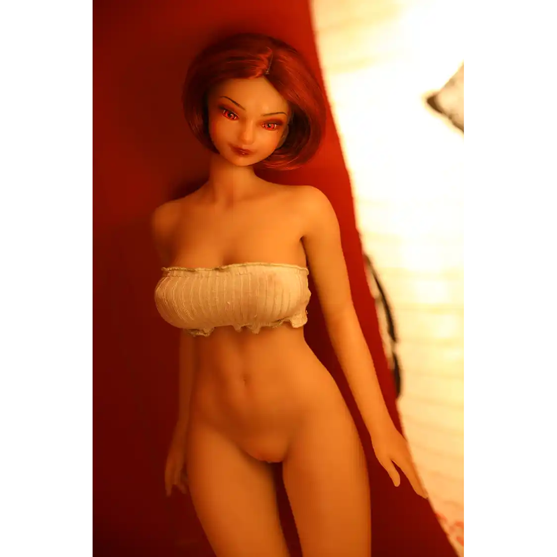 1ft 11in 60cm anime style female mini silicone sex doll with red hair, light skin and large breasts.