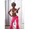 5ft 9in 175cm athletic black TPE sex doll with long legs, curly brown hair, large breasts and brown eyes in a sexy pink outfit.