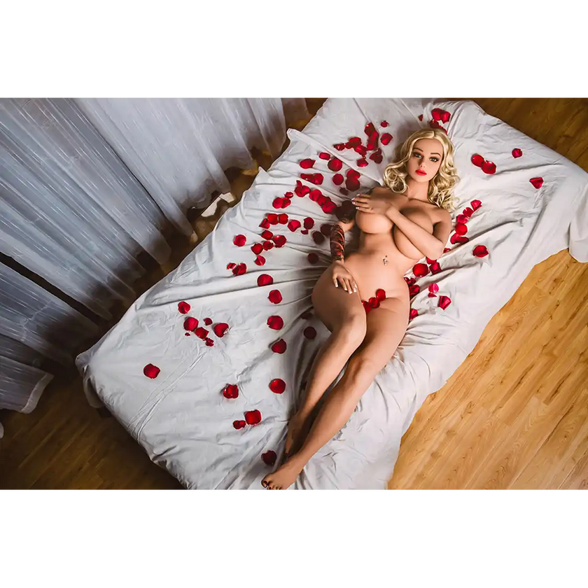 5ft 3in 160cm Caucasian female TPE sex doll with blonde hair, large breasts and a slim athletic figure with tattoos.