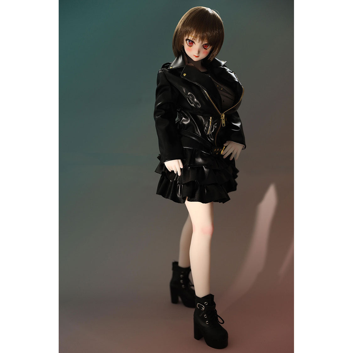 2ft 60cm mini anime sex doll Zella. Silicone body construction, giant breasts, fair skin, short dark hair and a curvy body in a  sheer top, black leather jacket and black skirt.