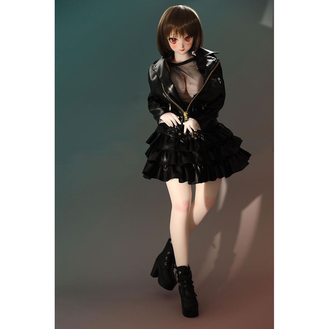 2ft 60cm mini anime sex doll Zella. Silicone body construction, giant breasts, fair skin, short dark hair and a curvy body in a  sheer top, black leather jacket and black skirt.