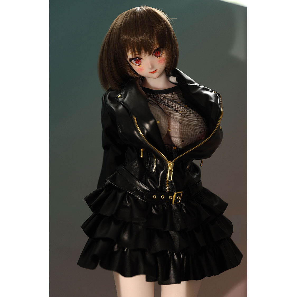 2ft 60cm mini anime sex doll Zella. Silicone body construction, giant breasts, fair skin, short dark hair and a curvy body in a  sheer top, black leather jacket and black skirt.