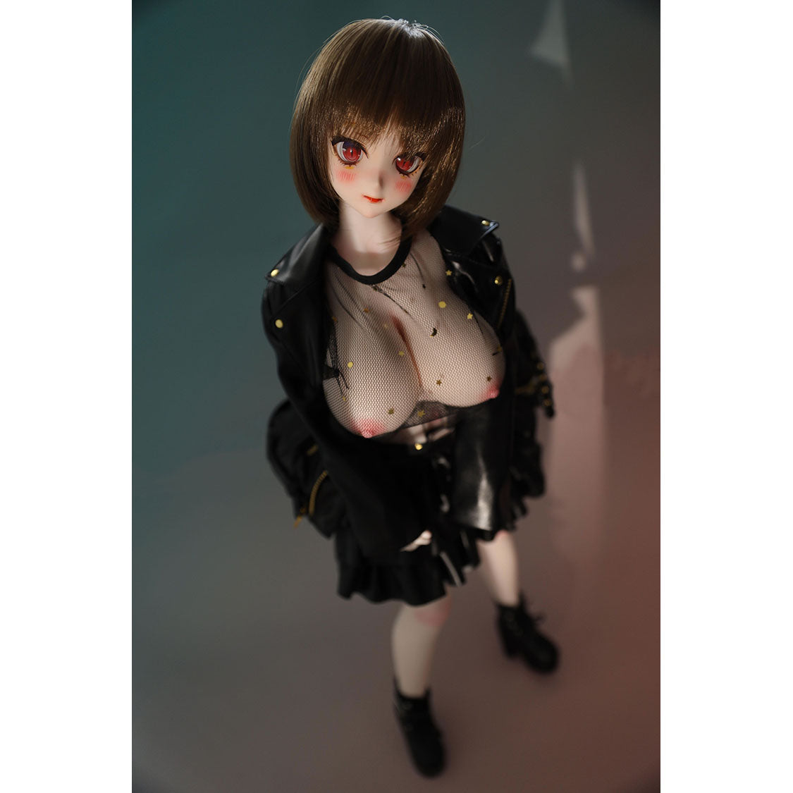 2ft 60cm mini anime sex doll Zella. Silicone body construction, giant breasts, fair skin, short dark hair and a curvy body in a  sheer top, black leather jacket and black skirt.