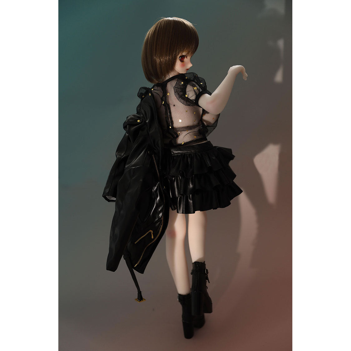 2ft 60cm mini anime sex doll Zella. Silicone body construction, giant breasts, fair skin, short dark hair and a curvy body in a  sheer top, black leather jacket and black skirt.