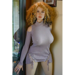 5ft 4in or 163cm tall life size hyper realistic MILF silicone sex doll with long legs, very large breasts and long curly blonde hair. Made by Normon Doll.